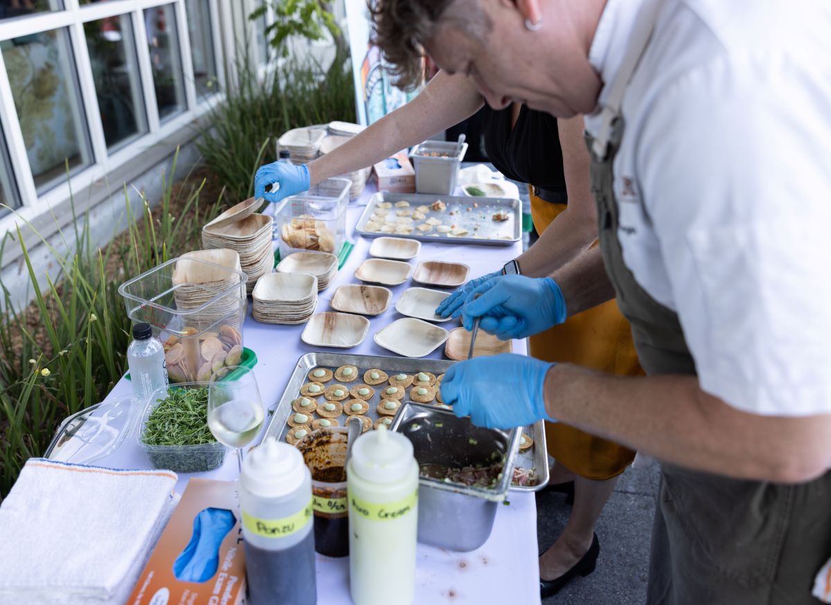 Chef preparing appetizers at outdoor food station.