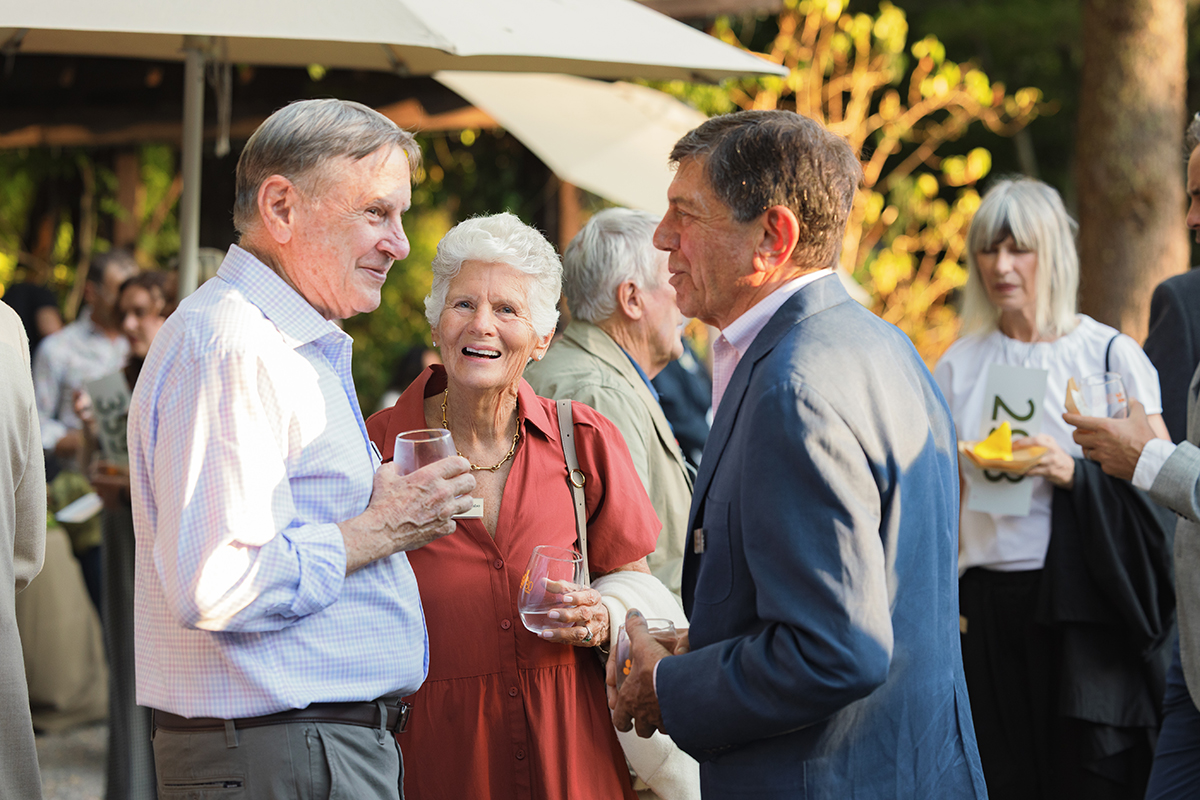 Several individuals socializing and drinking together at a lively outdoor gathering.