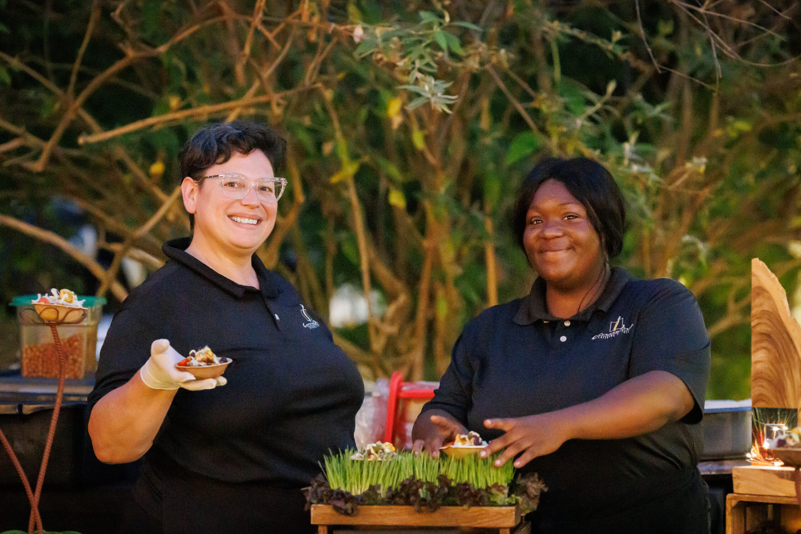 Two caterers hold food.