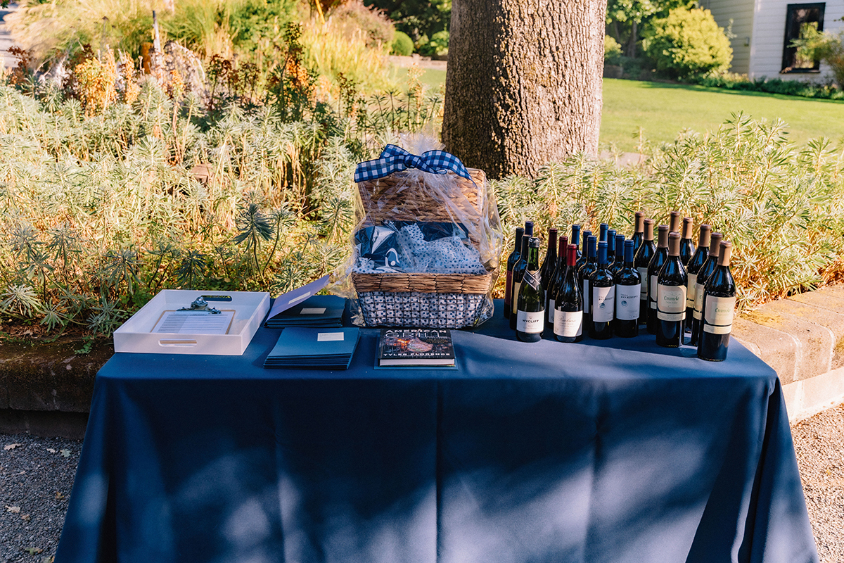 An elegant wine tasting table at an auction, showcasing a selection of wines and stylish glassware for attendees.
