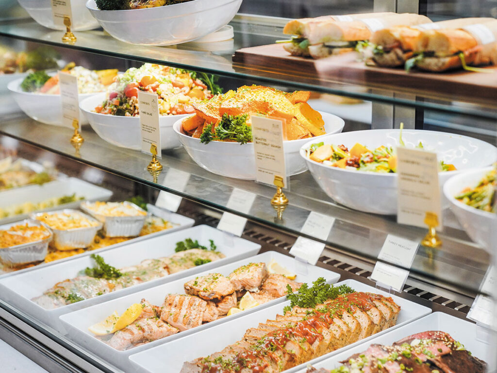 A food display case presenting an array of dishes, including desserts and savory options, attractively arranged.