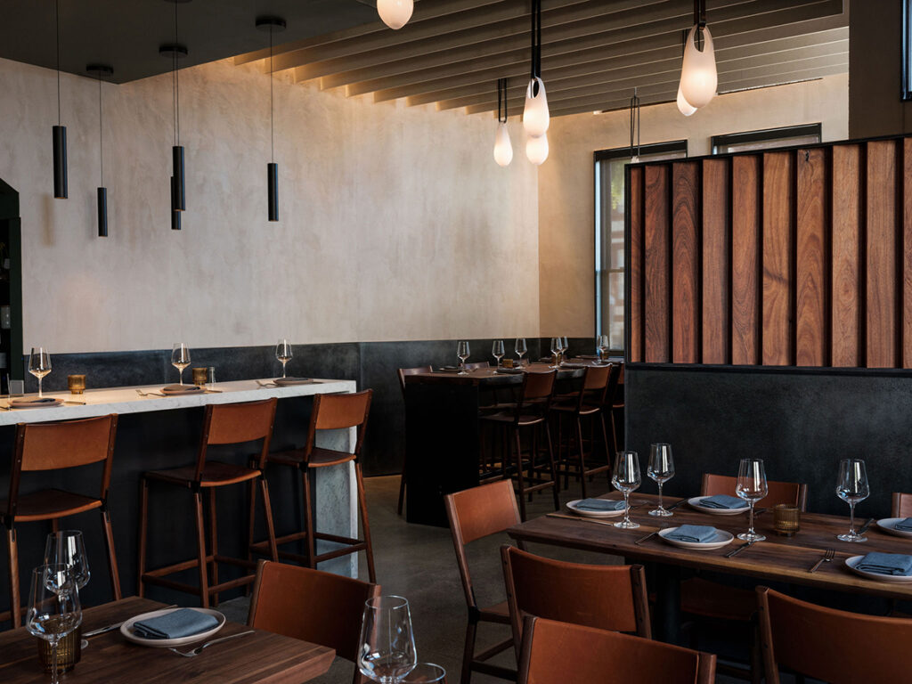 Interior of a restaurant showcasing warm wooden walls with elegant design elements.