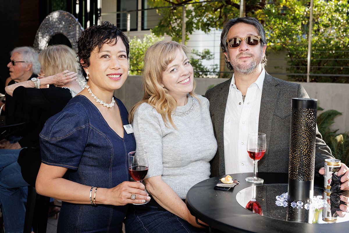 A group of people smiling and posing together for a photograph outdoors.