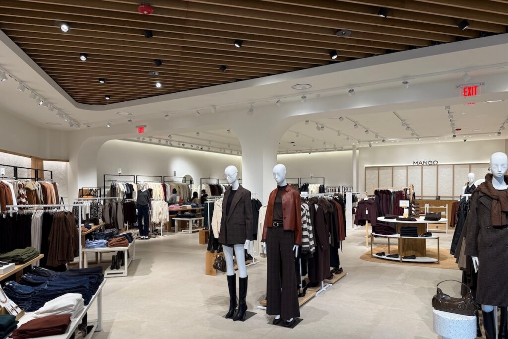 An overview of a store with racks of clothing and a few mannequins.