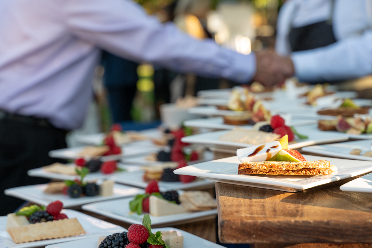 A buffet table filled with an assortment of dishes on plates, ready for guests to enjoy.