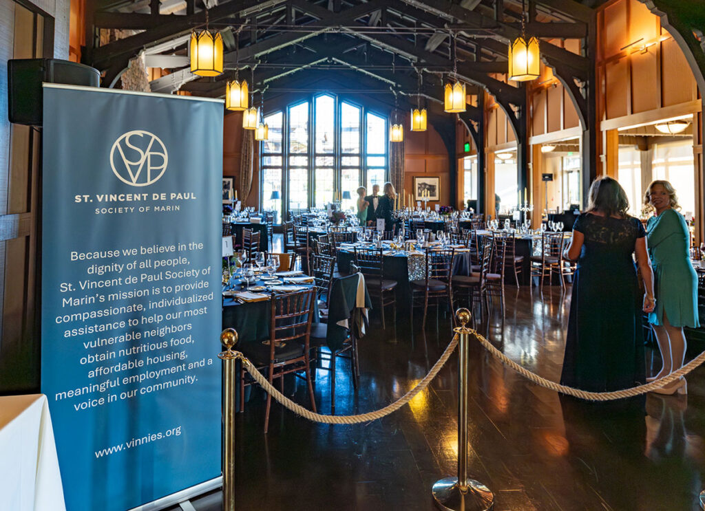 The event hall features elegantly arranged tables and chairs, creating a welcoming atmosphere for guests.