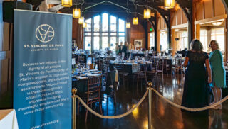 The event hall features elegantly arranged tables and chairs, creating a welcoming atmosphere for guests.