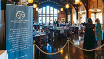 The event hall features elegantly arranged tables and chairs, creating a welcoming atmosphere for guests.