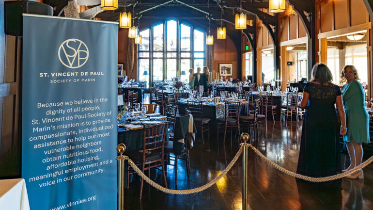 The event hall features elegantly arranged tables and chairs, creating a welcoming atmosphere for guests.