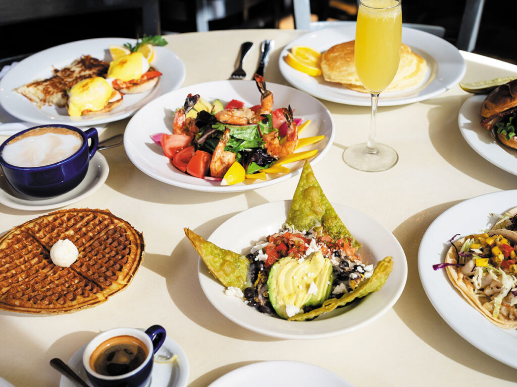 A table displaying an assortment of colorful plates filled with various dishes and food items.