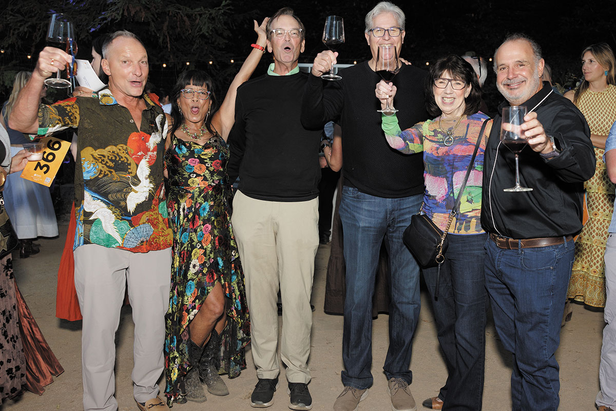 A group of diverse individuals cheerfully raising their glasses in a toast, celebrating a special occasion together.