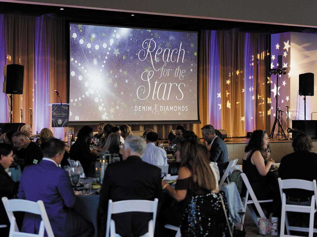 A large projector screen with a projector positioned nearby, ready for a presentation in a meeting space.