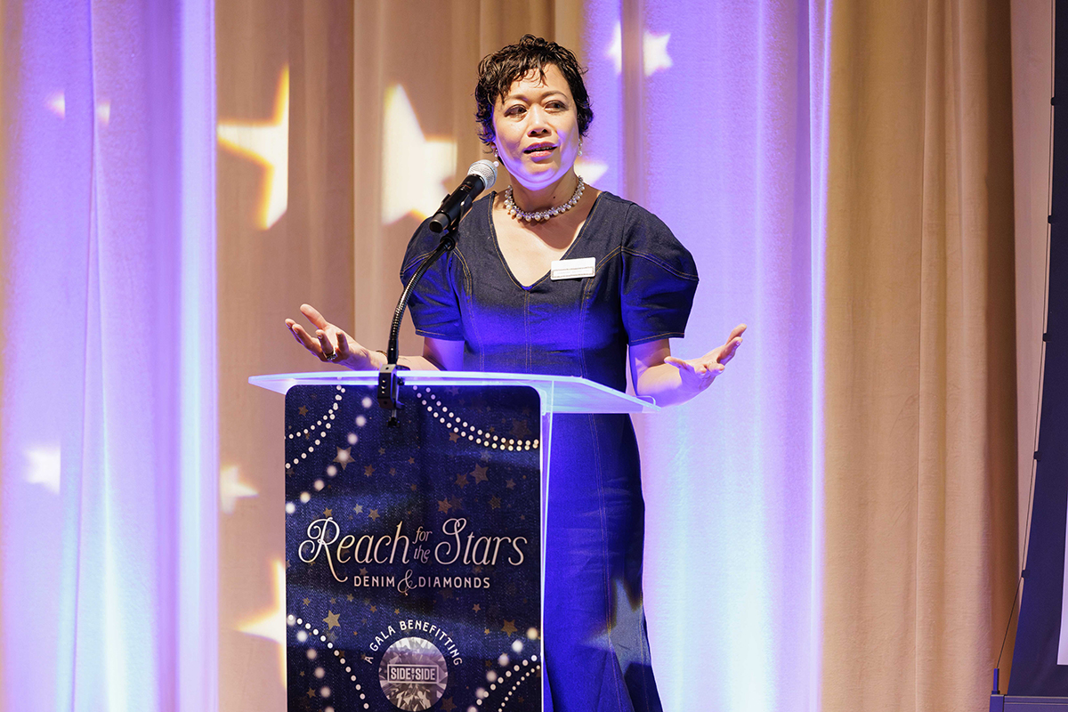 A woman speaking confidently at a podium, addressing an audience during an event.