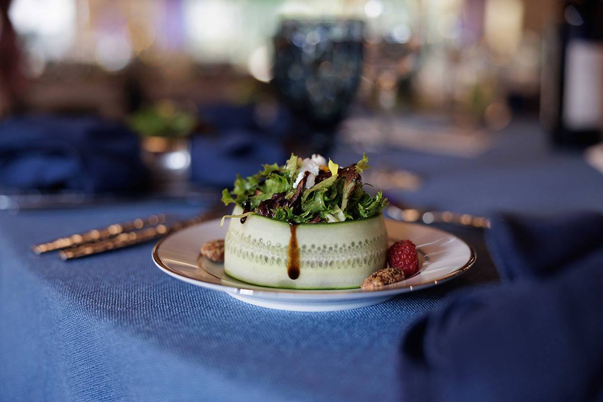 A small salad served on a plate, resting on a table, showcasing fresh greens and colorful vegetables.