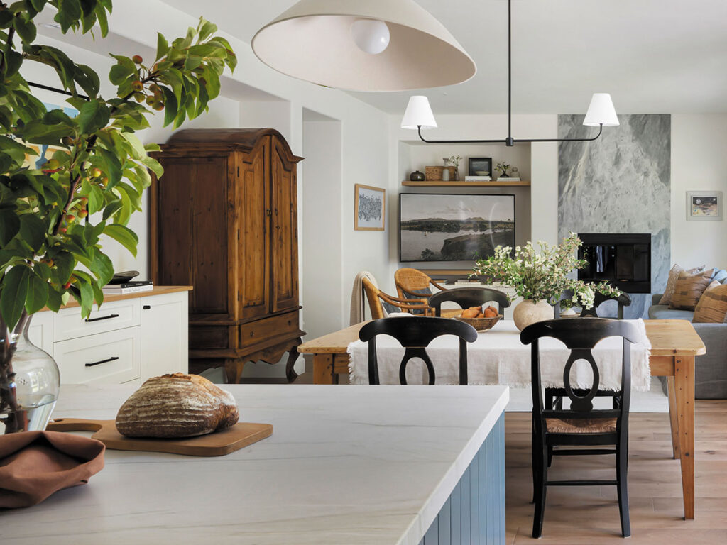 A kitchen featuring a wooden table surrounded by four chairs, with cabinets and appliances in the background.