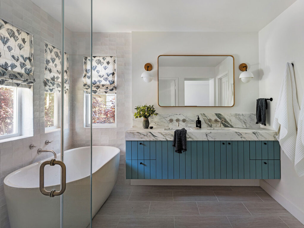A bathroom featuring blue cabinets and a white bathtub, creating a modern and inviting atmosphere.