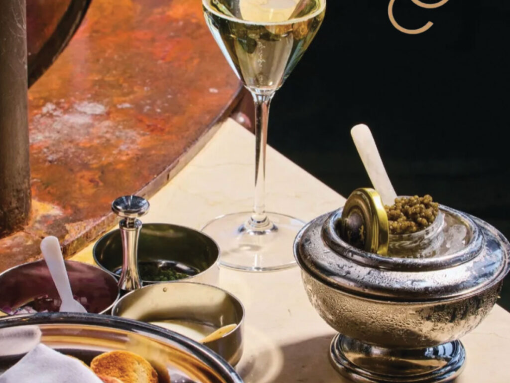 A glass of champagne beside a bowl of caviar, elegantly arranged for a luxurious dining experience.