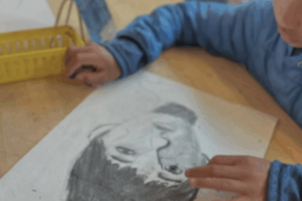 A child is working on a a pencil drawing of a portrait.