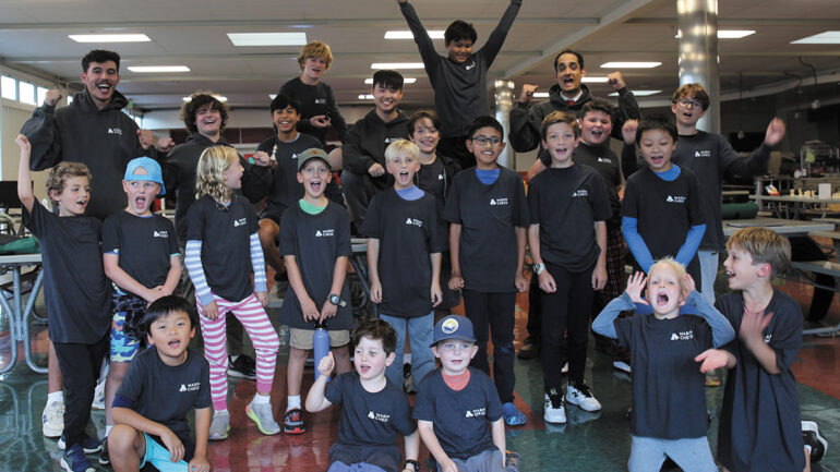 A cheerful group of children posing for a photograph, showcasing their excitement and friendship.