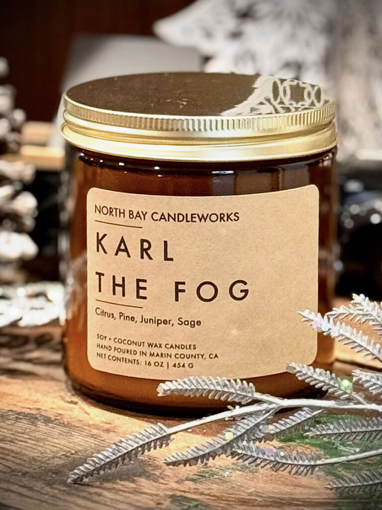 A Christmas candle labeled "Karl the Fog," featuring a festive design and warm glow