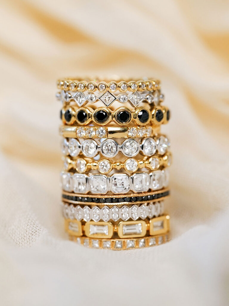 A stack of elegant gold and black diamond rings, showcasing a luxurious and sophisticated jewelry collection.