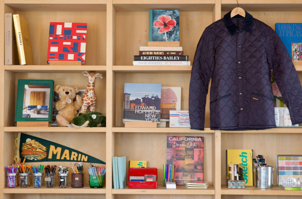 A bookshelf filled with various books and a jacket draped over one of the shelves
