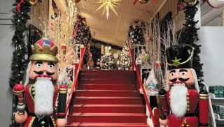 A beautifully decorated Christmas scene featuring nutcrackers, Christmas trees and a sparkling star
