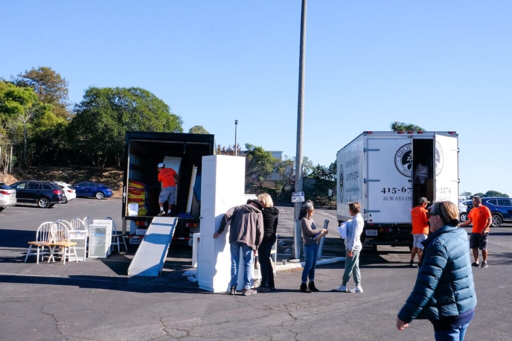 Moving trucks unloading in a parking lot.
