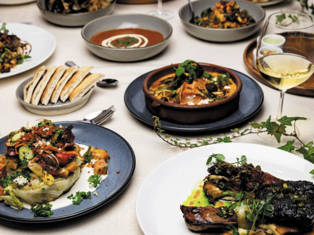 A beautifully arranged table featuring plates of food and wine, creating an elegant dining atmosphere.