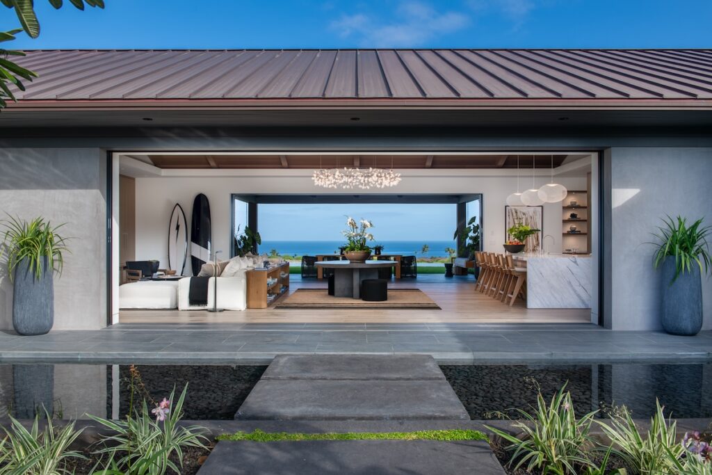 An home with an indoor/outdoor concept and a view of the ocean in the background.