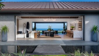 An home with an indoor/outdoor concept and a view of the ocean in the background.