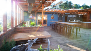 The patio of a restaurant featuring booth and bar seating.
