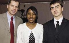 Three people stand together, smiling at the camera. The person on the left wears a tan suit with a red tie, the person in the middle wears a white and black polka dot outfit, and the person on the right wears a black suit with a white shirt and black tie. It looks like they're ready for an evening at one of their favorite clubs.