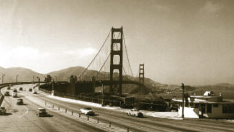 A sepia-toned photo of the Golden Gate Bridge. The bridge spans across a body of water, with cars on both the bridge and a nearby freeway. Mountains are visible in the background, evoking a mid-20th-century era with vintage vehicles on the roads, echoing the history of Marin Conservation League's early efforts.