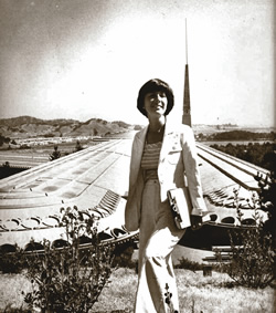 a woman in front of a water resevoir
